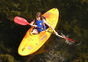 Young girl kayaking on family adventure vacation