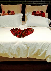 Hotel bed with roses arranged as a heart