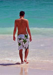 Man walking on a beach in boxer swimwear