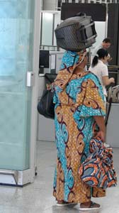 Woman carrying her international traveler luggage on her head