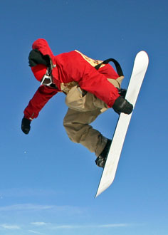 Snowboarder jumping on his snowboard