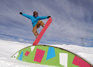 Young boy jumping on his snowboard