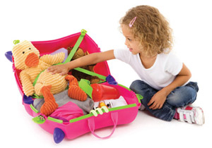 Young girl packing her luggage into Trunki childrens luggage