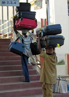Men carrying too much carry on luggage