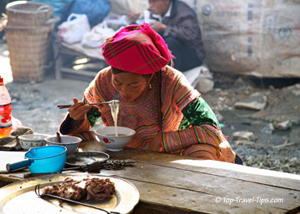 Woman eating soup in market restaurant