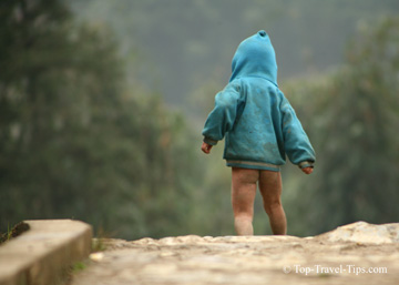 Young kid in a jumper playing alone in a Vietnam village