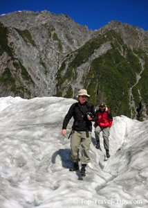 Two people wearing travel clothes on glacier