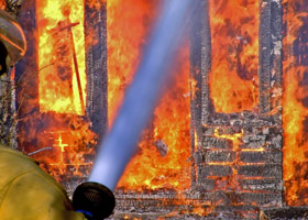 Fire fighter putting out house fire